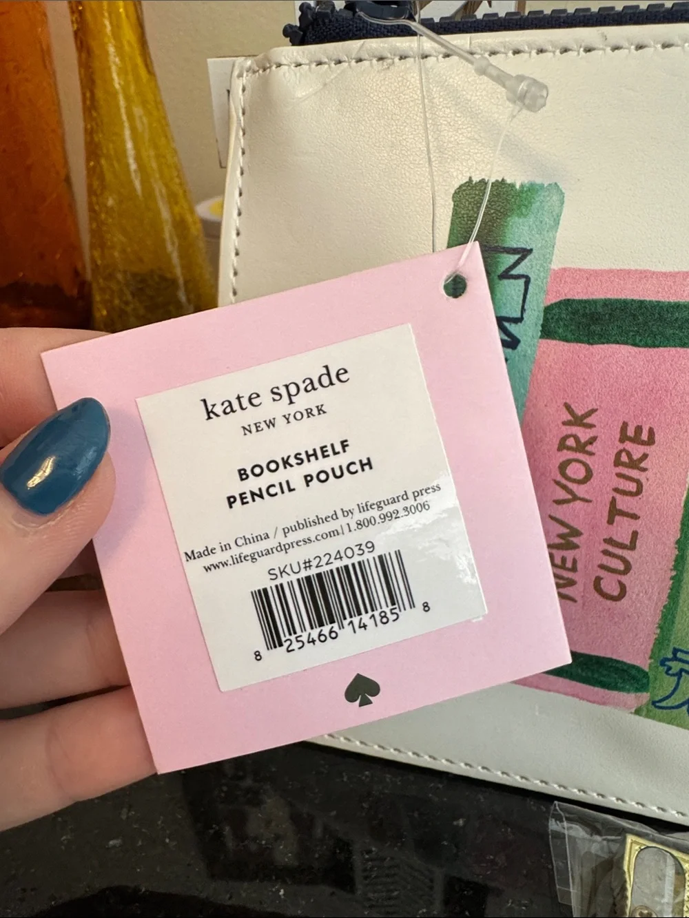 kate spade white pouch with colorful book spine print